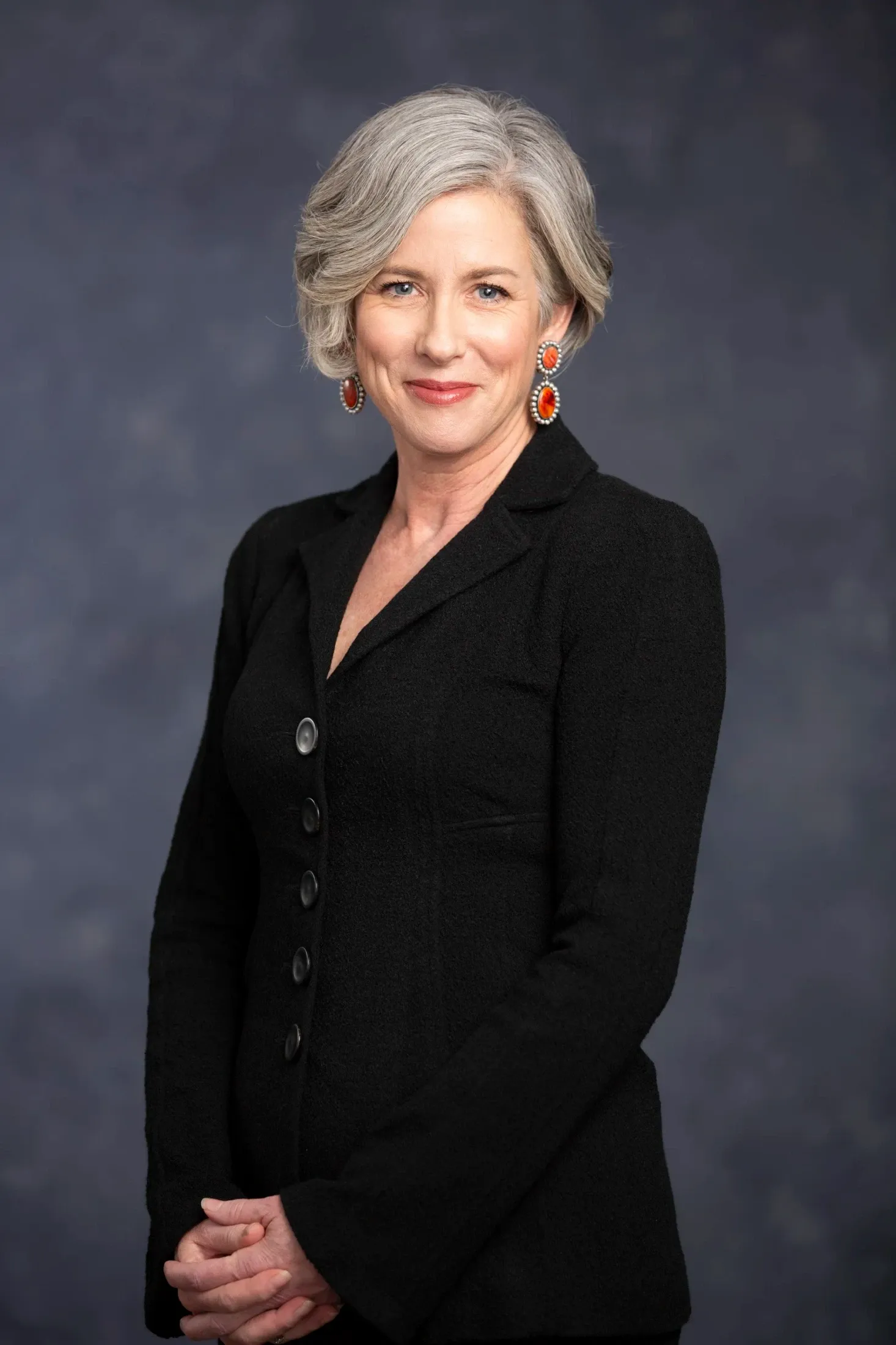 A professional woman with gray hair in a black jacket